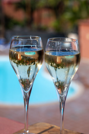 Pouring a glass of champagne on vacation, south of Fuerteventura, Canary islands, blue ocean, mountains, Spainの写真素材