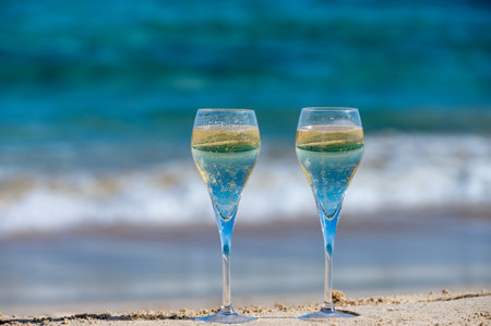 Pouring a glass of champagne on vacation, south of Fuerteventura, Canary islands, blue ocean, mountains, Spainの写真素材