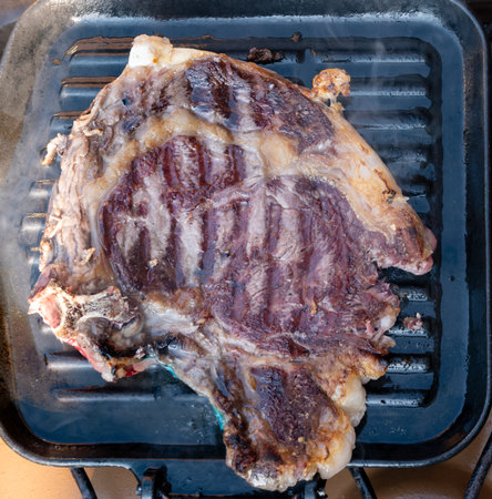 Large beef rib eye steak grilled on gas stove grill in small village restaurant in Tuscany, Italyの写真素材