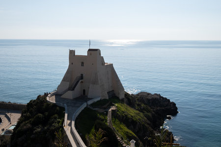 View on white harbor tower from hilly medieval small touristic coastal town Sperlonga and sea shore, Latina, Italy in winterの写真素材