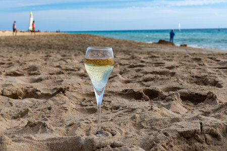 Pouring a glass of champagne on vacation, south of Fuerteventura, Canary islands, blue ocean, mountains, Spainの写真素材