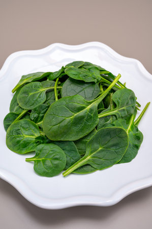 Fresh green baby Spinach leaves, diet and health concept, weight loss, washed spinach on ceramic plate, copy spaceの写真素材