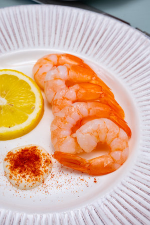 Catch of the day, fresh cooked shrimps served with lemon and garlic sauce on white plate in seafood restaurantの写真素材