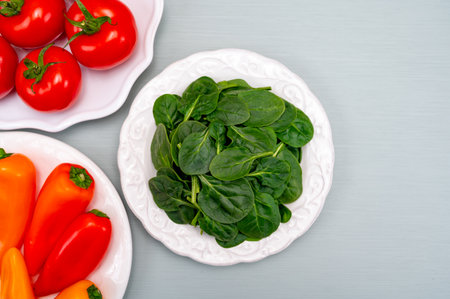 Fresh tomatoes, paprika, green spinach leaves, diet and health concept, weight loss, spinach on...