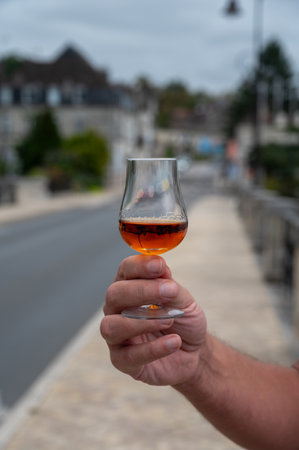 Tasting of aged in barrels cognac alcohol drink and view on old streets and houses in town Cognac, Grand Champagne, Charente, strong spirits distillation industry, Franceの写真素材