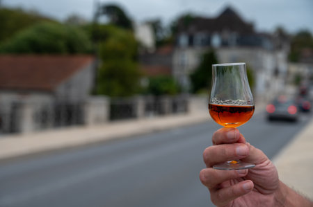 Tasting of aged in barrels cognac alcohol drink and view on old streets and houses in town Cognac, Grand Champagne, Charente, strong spirits distillation industry, Franceの写真素材