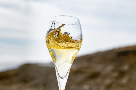 Pouring a glass of champagne on vacation, south of Fuerteventura, Canary islands, blue ocean, mountains, Spainの写真素材
