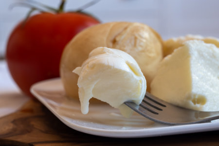 Tasty Italian food, small balls of smoked and white mozzarella soft cheese served on white boardの写真素材