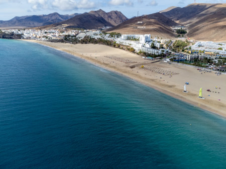 White sandy beach and blue ocean water in Morro Jable vacation village on south of Fuerteventura, Canary islands, Spain in winterの写真素材