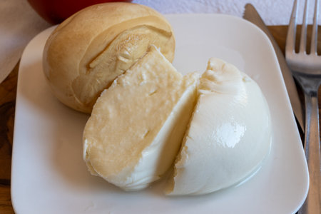Tasty Italian food, small balls of smoked and white mozzarella soft cheese served on white boardの写真素材