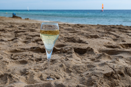 Pouring a glass of champagne on vacation, south of Fuerteventura, Canary islands, blue ocean, mountains, Spainの写真素材