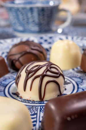 Variety of luxury belgian chocolate pralines bonbons on blue china porcelain plate, tea time, close upの写真素材