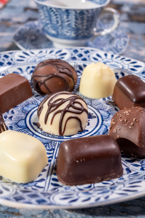 Variety of luxury belgian chocolate pralines bonbons on blue china porcelain plate, tea time, close upの写真素材