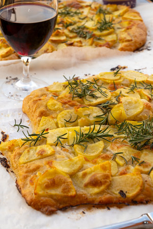 Fresh baked focaccia, pala romana pizza with potato vegetables and rosemary in bakery in Parma, Emilia Romania, Italyの写真素材