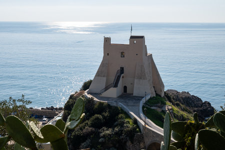 View on white harbor tower from hilly medieval small touristic coastal town Sperlonga and sea shore, Latina, Italy in winterの写真素材