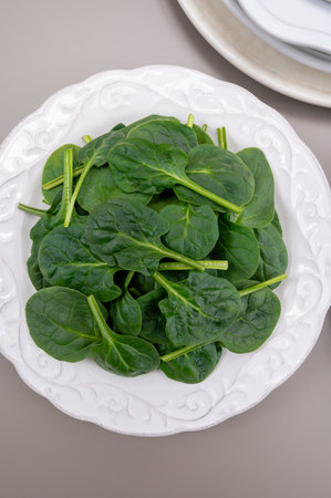 Fresh green baby Spinach leaves, diet and health concept, weight loss, washed spinach on ceramic plate, copy spaceの写真素材