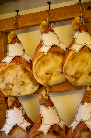 Prosciutto crudo, prosciutto di Parma, uncooked, unsmoked, and dry-cured ham from Parma, Emilia-Romagna, Italy, pork legs hanging in restaurantの写真素材