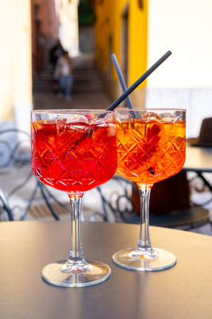 Aperol and Campari Spritz orange bitter long drink cocktail made with liqueur, prosecco sparkling wine, ice cubes and piece of orange, Bellagio, Italyの写真素材