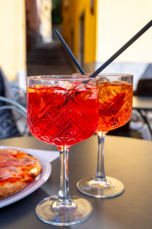 and Spritz orange bitter long drink cocktail made with liqueur, prosecco sparkling wine, ice cubes and piece of orange, Bellagio, Italyの写真素材