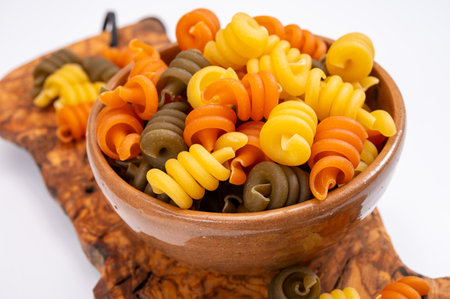 Traditional colorful tricolore Italian dried homemade pasta from Naples, Italy on olive wood boardの写真素材