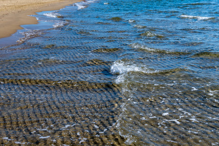 Crystal clear sea water texture with glare from the sun, wallpaper, nature background