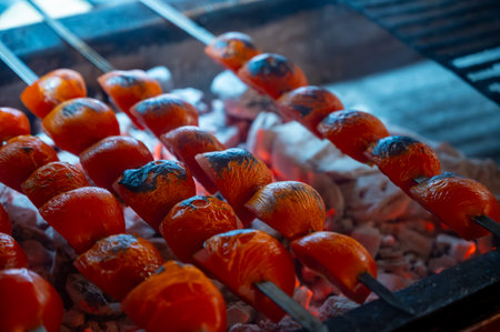 Barbecue with ripe red tomatoes on flamed charcoal grill in turkish restaurantの写真素材