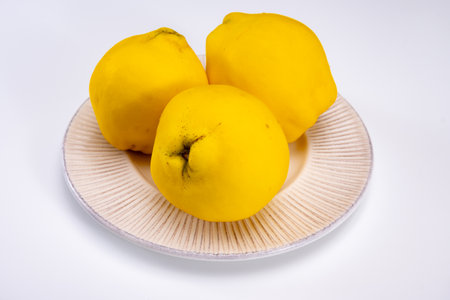 Group of ripe yellow quince apples close up on white background isolatedの写真素材