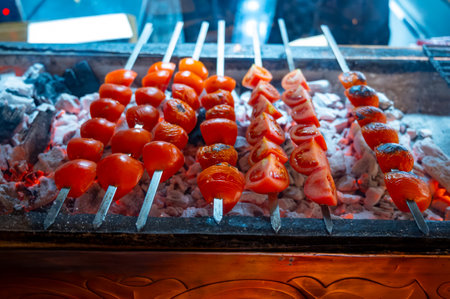 Barbecue with ripe red tomatoes on flamed charcoal grill in turkish restaurantの写真素材