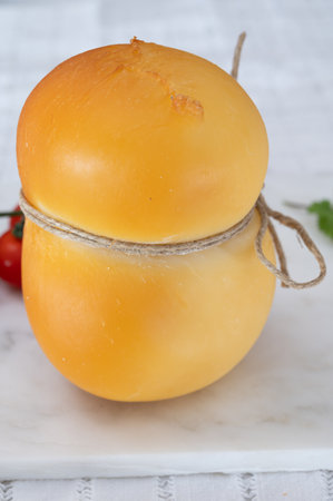 Cheese collection, Italian cheese scamorza, caciocavallo, provolone made from cow milk in South Italy yellow smoked cheese close upの写真素材