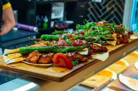 Wooden plate with Turkish mixed grill meat, chicken wings, lamb, beef shashlik, kebab, peppers from charcoal grill in restaurant in Istanbulの写真素材