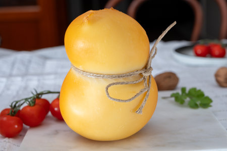 Cheese collection, Italian cheese scamorza, caciocavallo, provolone made from cow milk in South Italy yellow smoked cheese close upの写真素材