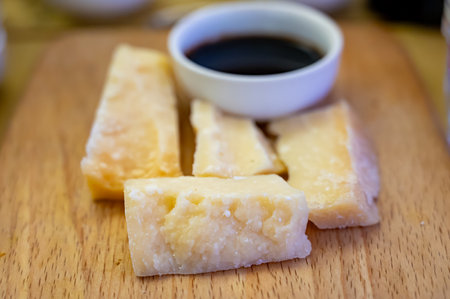 Tasting of different matured and very old parmesan Italian Parmigiano-Reggiano hard cheese and balsamic vinegar of Modena in Parma, Emilia Romagna, Italyの写真素材