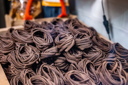 Italian food, dried handmade colorful pasta tagliatelle with added cacao beans, ready to cook, Milan, Lombardy, Italyの写真素材