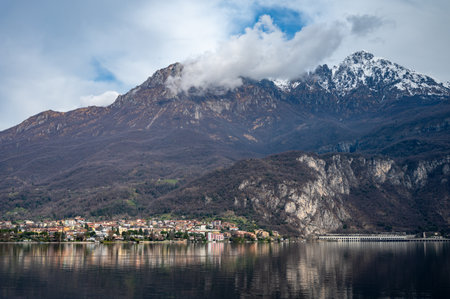 Driving car on road along shores of Lake Como in Northern Italy, spring sunny days, views of alpine mountains, water and villagesの写真素材