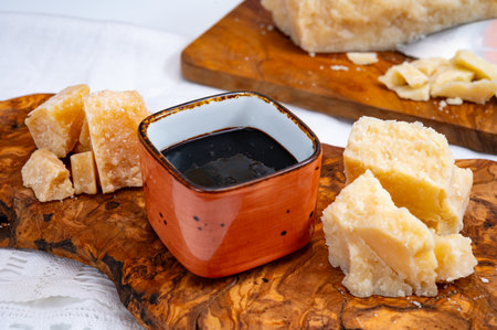 Tasting of 24 and 48 months aged in caves Italian parmesan hard cheese from Parmigiano-Reggiano, Italy and balsamic vinegar from Modenaの写真素材