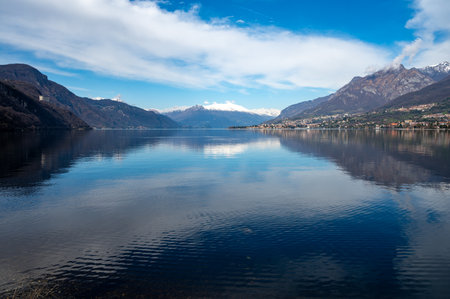 Driving car on road along shores of Lake Como in Northern Italy, spring sunny days, views of alpine mountains, water and villagesの写真素材