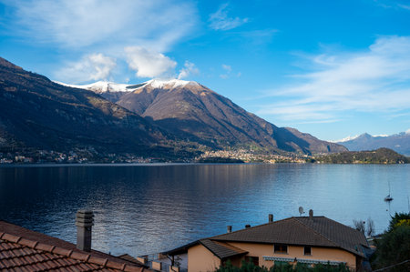 Driving car on road along shores of Lake Como in Northern Italy, spring sunny days, views of alpine mountains, water and villagesの写真素材