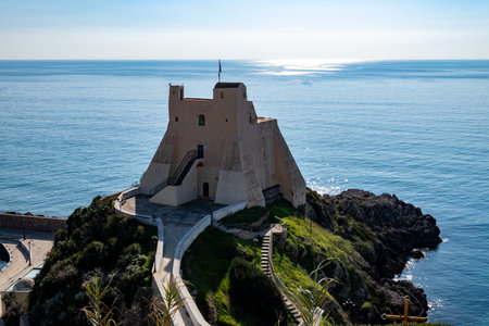 View on white harbor tower from hilly medieval small touristic coastal town Sperlonga and sea shore, Latina, Italy in winterの写真素材
