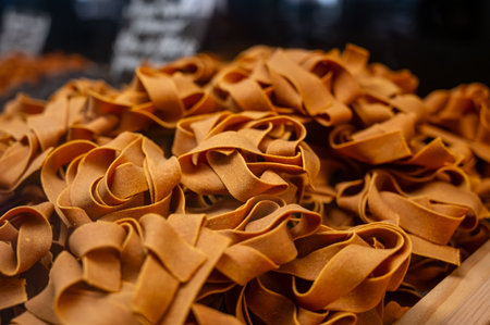 Italian food, dried handmade colorful pasta pappardelle with red saffron, ready to cook, Milan, Lombardy, Italyの写真素材
