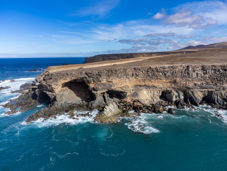 West coast of Fuerteventura island. View on blue water and black volcanic caves of Ajuy village, Canary islands, Spain.の写真素材