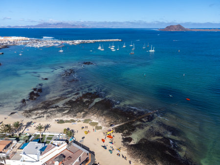 Aerial view Corralejo town, harbour, black rocks, blue water, Lobos and Lanzarote islands, Fuerteventura, Canary islands, Spain, winter sun vacationの写真素材
