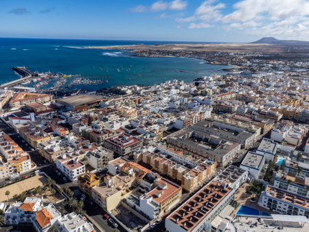 Aerial view Corralejo town, harbour, black rocks, blue water, Lobos and Lanzarote islands, Fuerteventura, Canary islands, Spain, winter sun vacationの写真素材