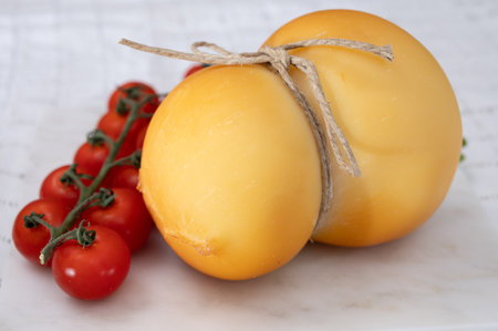 Cheese collection, Italian cheese scamorza, caciocavallo, provolone made from cow milk in South Italy yellow smoked cheese close upの写真素材