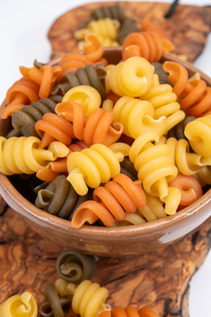 Traditional colorful tricolore Italian dried homemade pasta from Naples, Italy on olive wood boardの写真素材