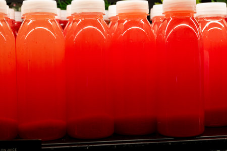 Bottles with cold red fresh pressed red strawberry juice with fresh berriesの写真素材
