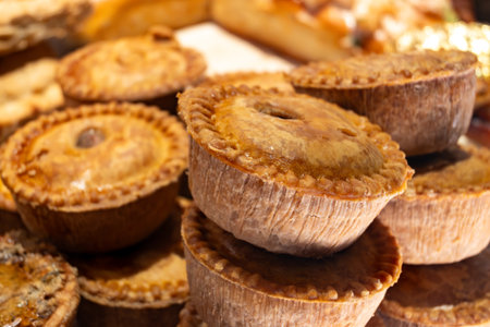 Fresh baked stuffed meat pies, British pastries, snacks on display in shop in Londonの写真素材