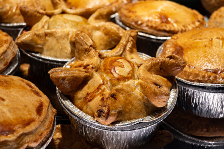 Fresh baked stuffed meat pies, British pastries, snacks on display in shop in Londonの写真素材