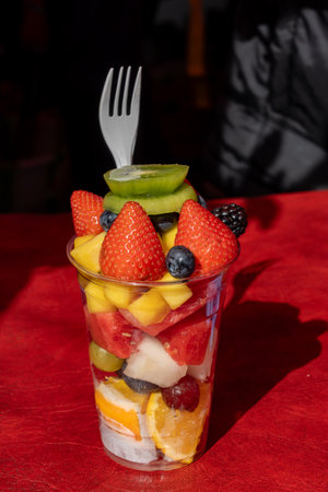 Healthy snack, dessert, colorful fresh fruits and berries cutted in pieces and served in plastic glass, street food, portobello road market, Londonの写真素材