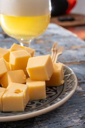 Cheese collection, Dutch ripe hard cheeses made from cow milk in the Netherlands in cubes and glass of white beerの写真素材