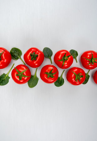 Food ornament, Red ripe tasty Dutch tomatoes and spinach leaves, healthy vegetables background top view close up, copy spaceの写真素材